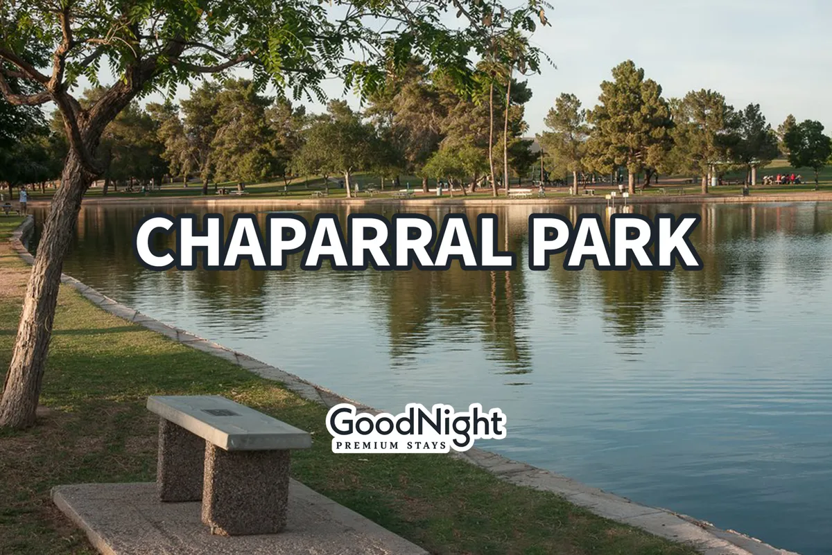 A tranquil lake scene features a shaded bench beneath trees, inviting visitors to walk, jog, or simply enjoy a quiet moment of reflection. The still water and lush greenery create a peaceful atmosphere for outdoor recreation or relaxation.