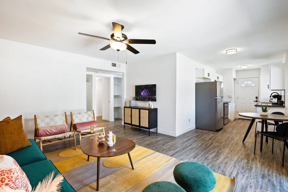An open-concept living space that includes a sofa, coffee table, dining area, kitchen, and a television. The arrangement is casual and comfortable, promoting both relaxation and group interaction, ideal for family game nights or intimate gatherings.